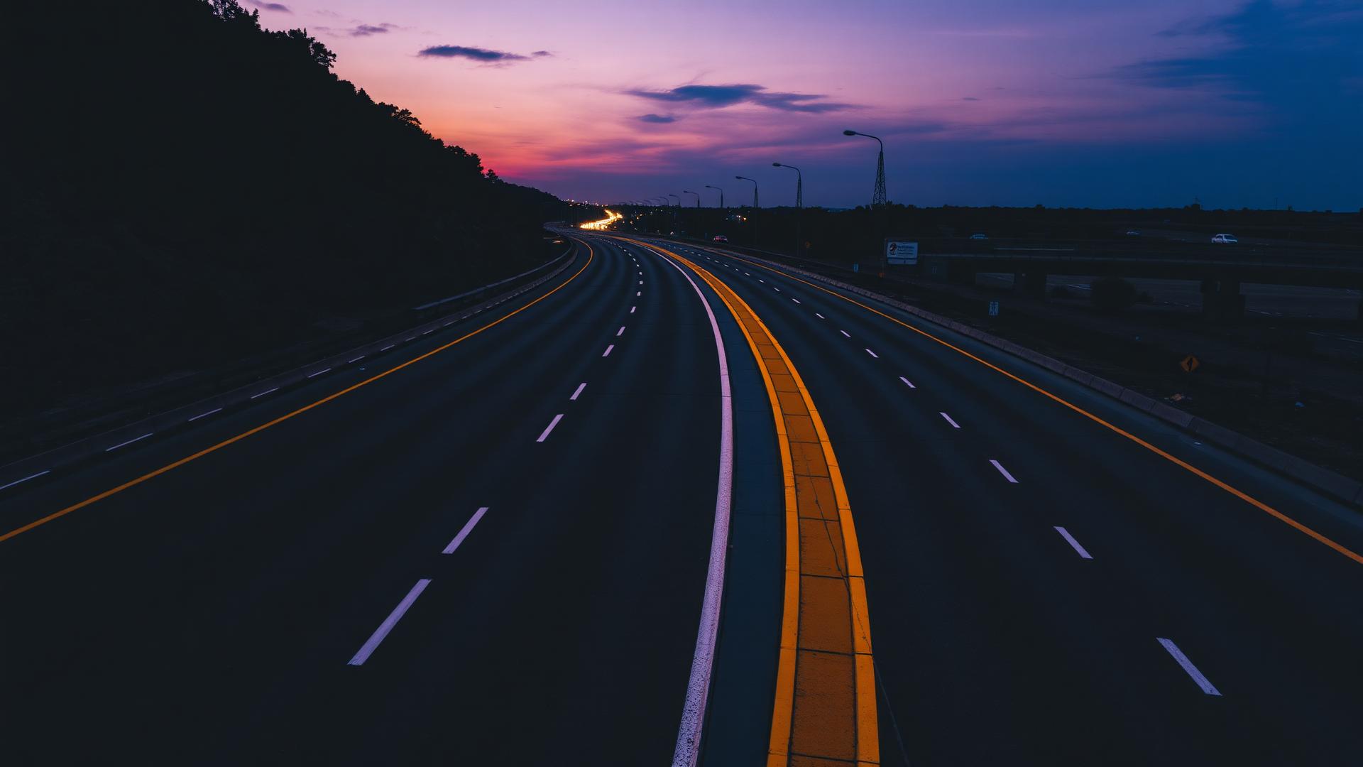 Carretera al atardecer con señalización amarilla